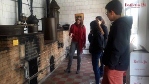 La guía explica el funcionamiento del alambique durante una de las visitas guiadas a la Destilería.